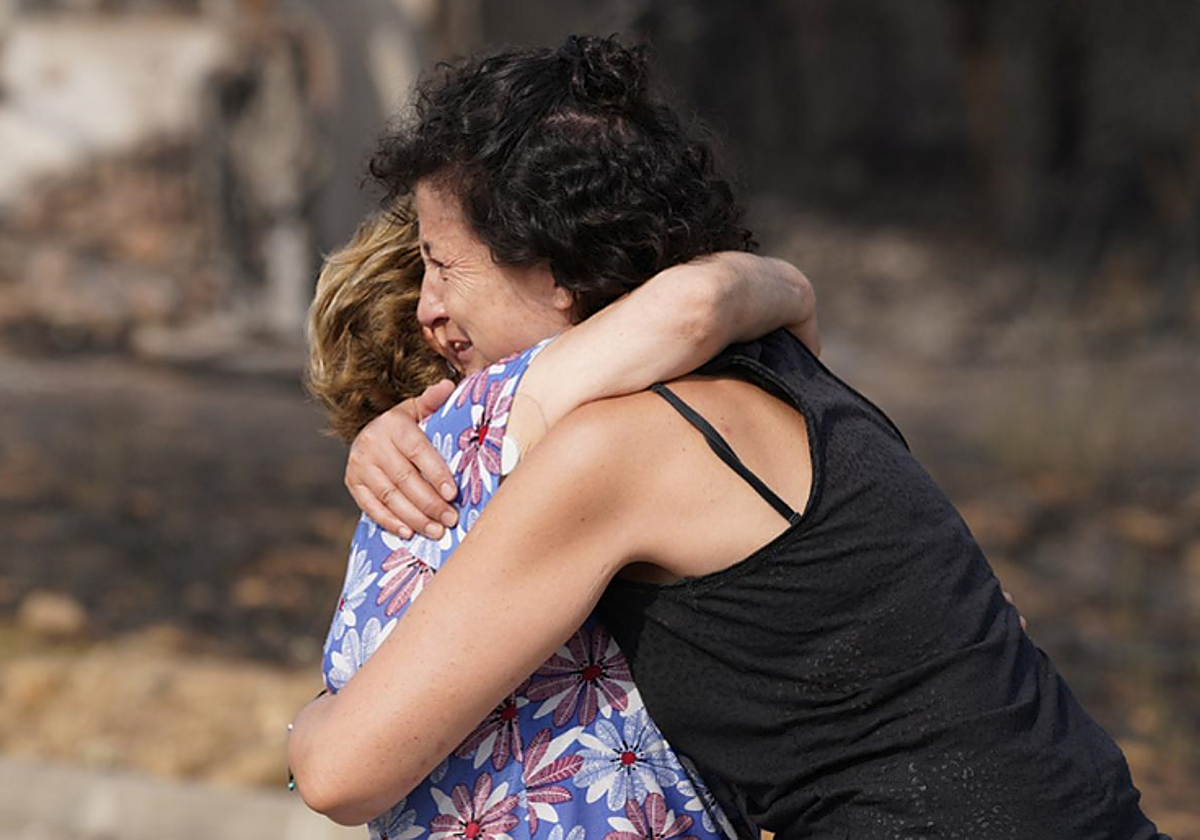 Dos vecinas de Las Médulas se abrazan y lloran ante la magnitud del desaste originado por el incendio.