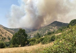 La abadía de Lebanza, casi cubierta en la imagen por los árboles, y el fuego acercándose.