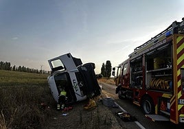 Los bomberos ayudan al conductor del camión tras el accidente.