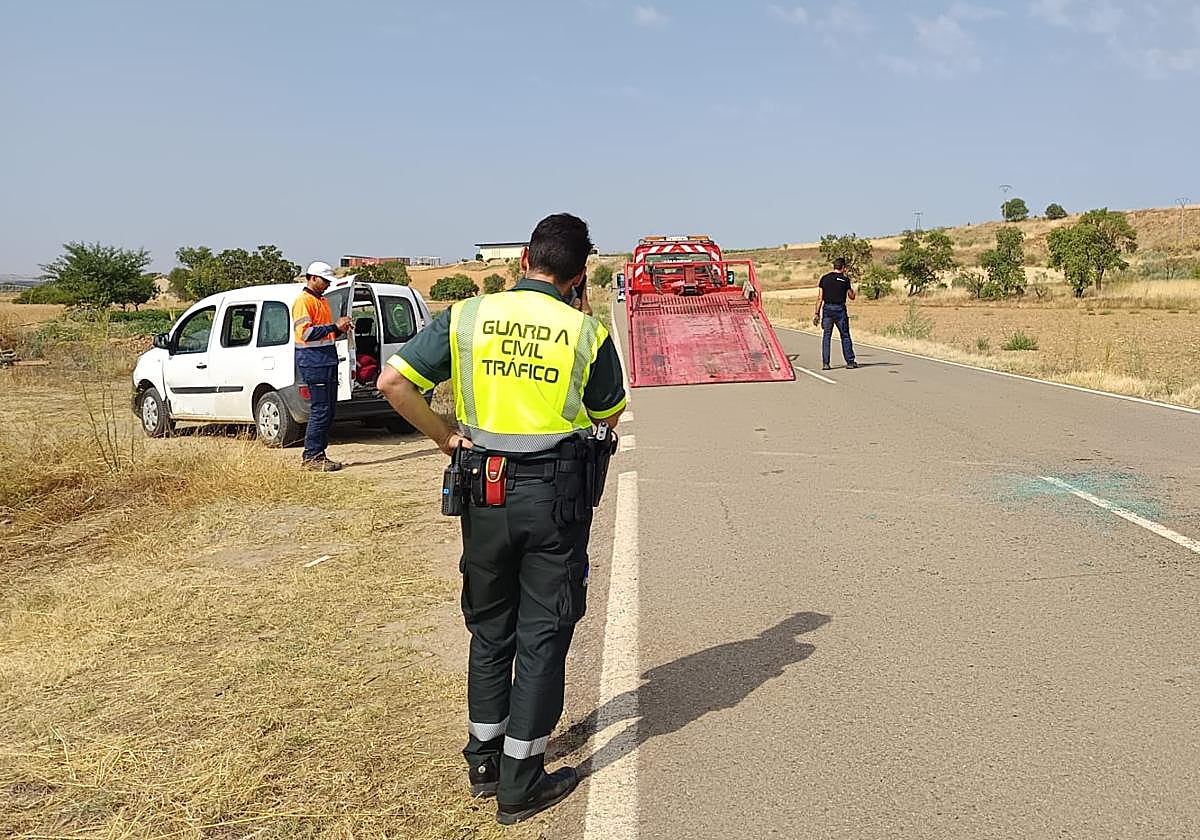 Un agente de la Guardia Civil y una grúa en el lugar del suceso.