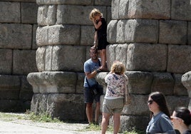 Un niño, subido a uno de los sillares del Acueducto de Segovia.