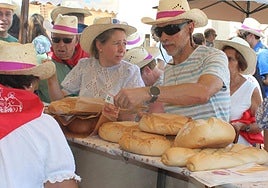El público, protegido por sombreros contra el sol, recorre los puestos de la feria.