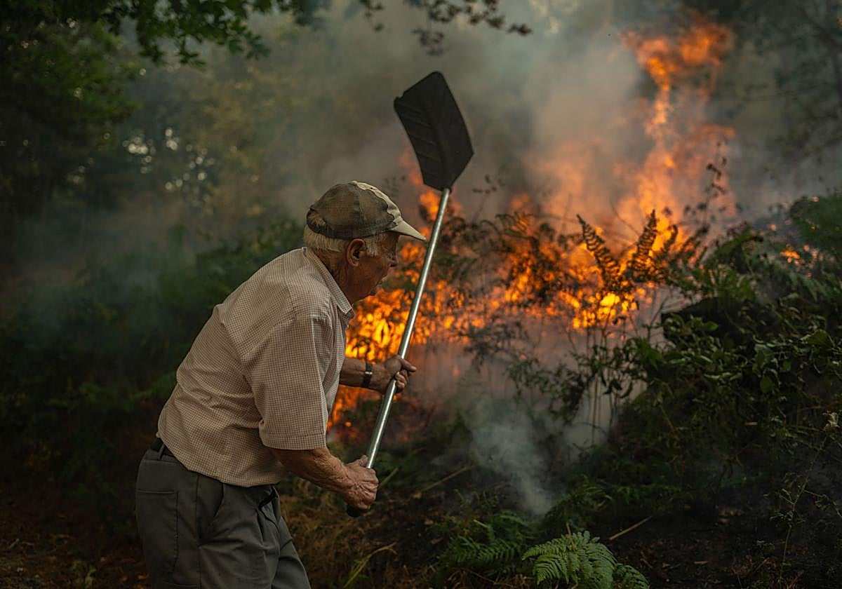 Un hombre trata de luchar contra el fuego.
