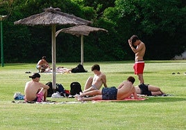 Un grupo de jóvenes conversan en una piscina.