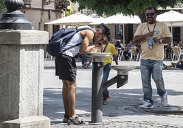 Varias personas se refrescan con agua durante una jornada de la ola de calor.
