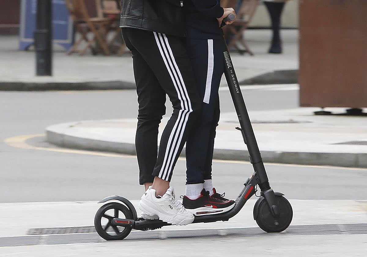 Dos personas en un patinete eléctrico, en imagen de archivo.