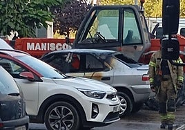 Los Bomberos de Aranda trabajan en el lugar del coche incendiado.