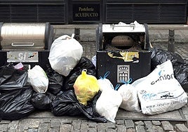 Basura amontonada junto a contenedores en una céntrica calle de Segovia.