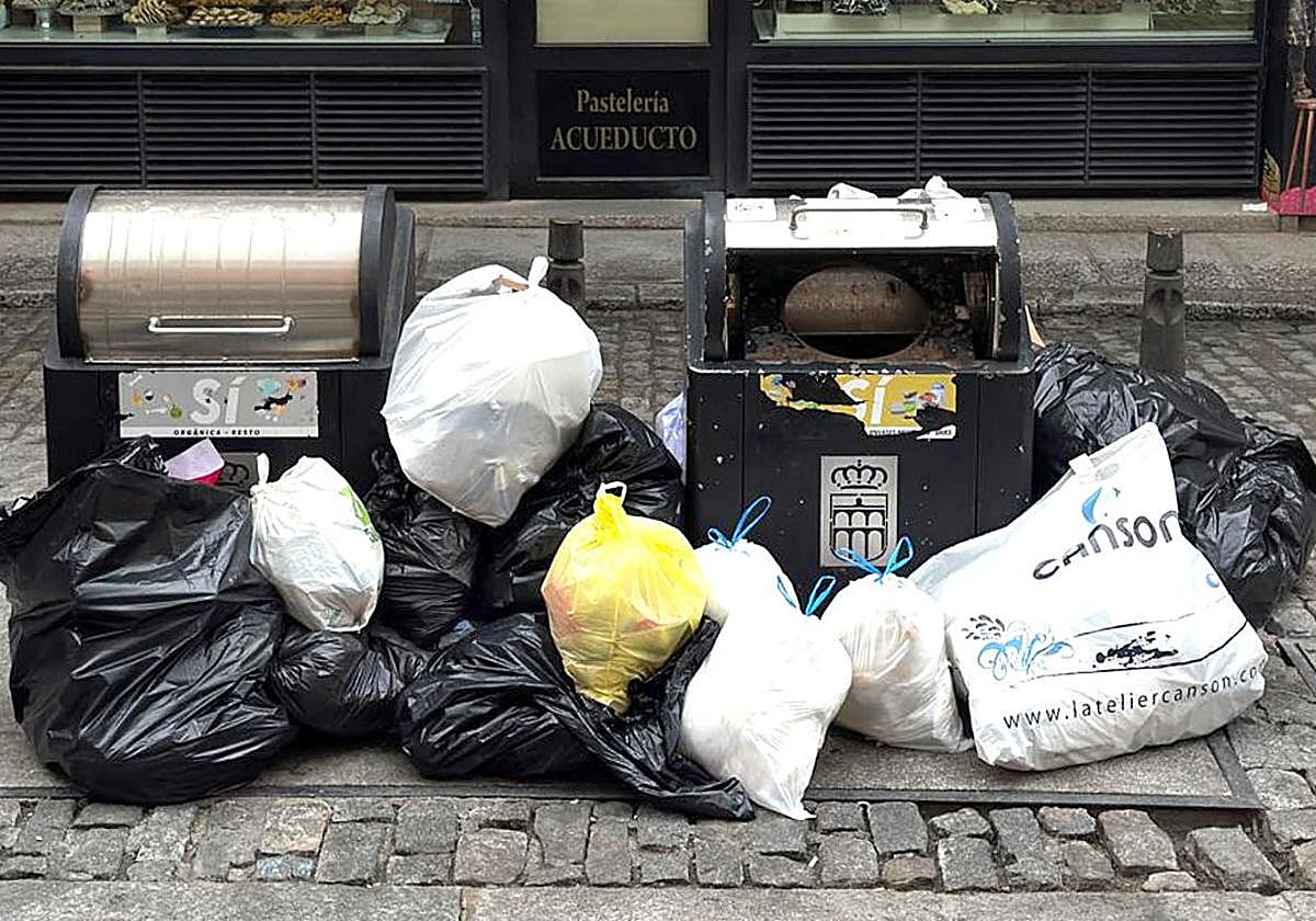 Basura amontonada junto a contenedores en una céntrica calle de Segovia.