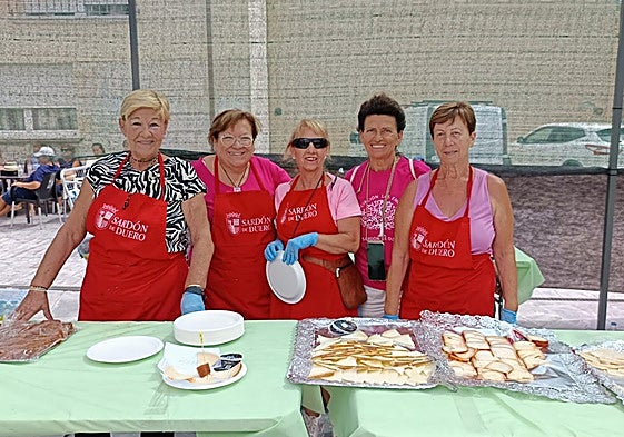 Un grupo de mujeres repartan las tapas de queso en la pasada edición