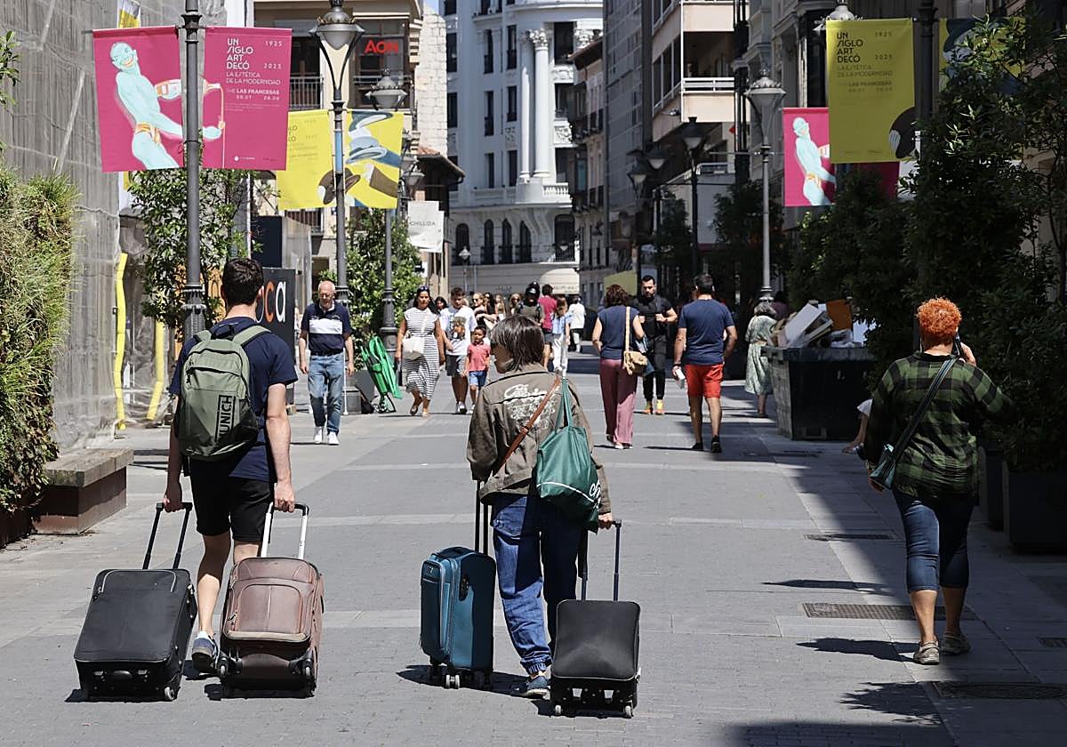 Viajeros con maletas por la calle Santiago, este mes de agosto.