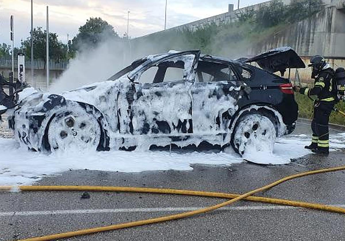 Un bombero de la Diputación remata la extinción del BMW X6 robado y quemado en Arroyo, el pasado mes de mayo.