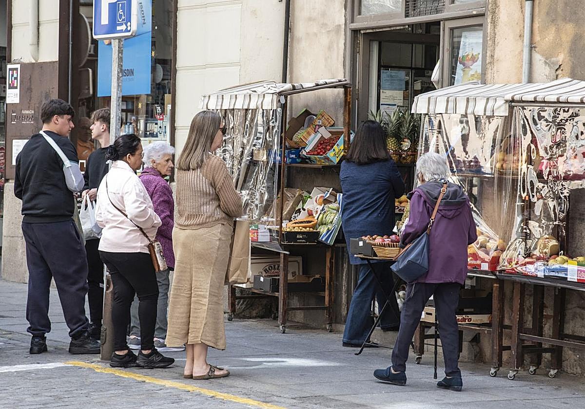 Varias personas esperan su turno para comprar en una frutería próxima a la Plaza Mayor.