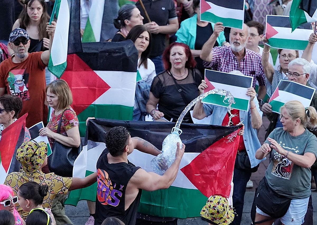 Imagen secundaria 1 - Unos jóvenes con la bandera de España recriminan a un grupo que reivindicaba una 'Palestina Libre' durante el pregón de las fiestas
