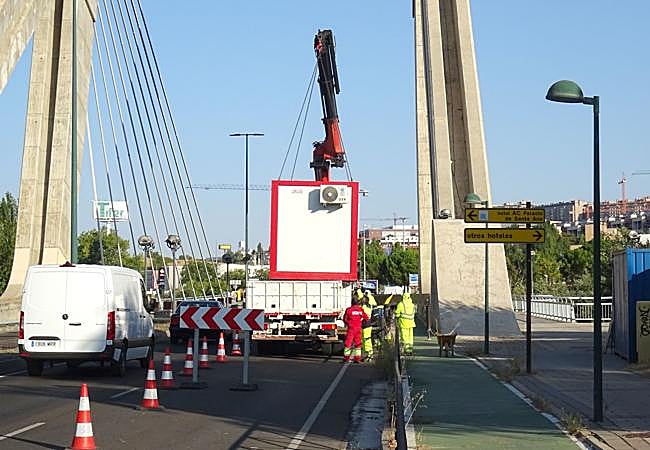 Una grúa retira la caseta de obra antes de la reapertura del carril cortado del puente de Hispanoamérica.