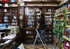 Un comerciante coloca productos en su tienda.