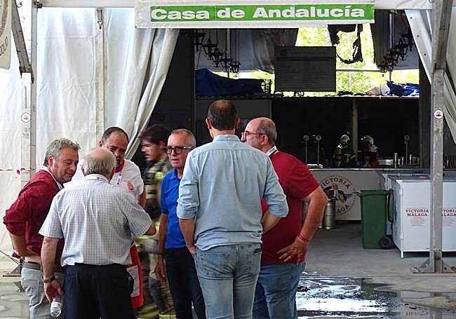 El concejal de Urbanismo (de azul) conversa con los responsables de las casetas regionales ante la carpa incendiada.