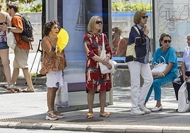 Un grupo de mujeres en una parada de autobús.