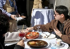 Un turista paga la cuenta tras almorzar en una terraza.