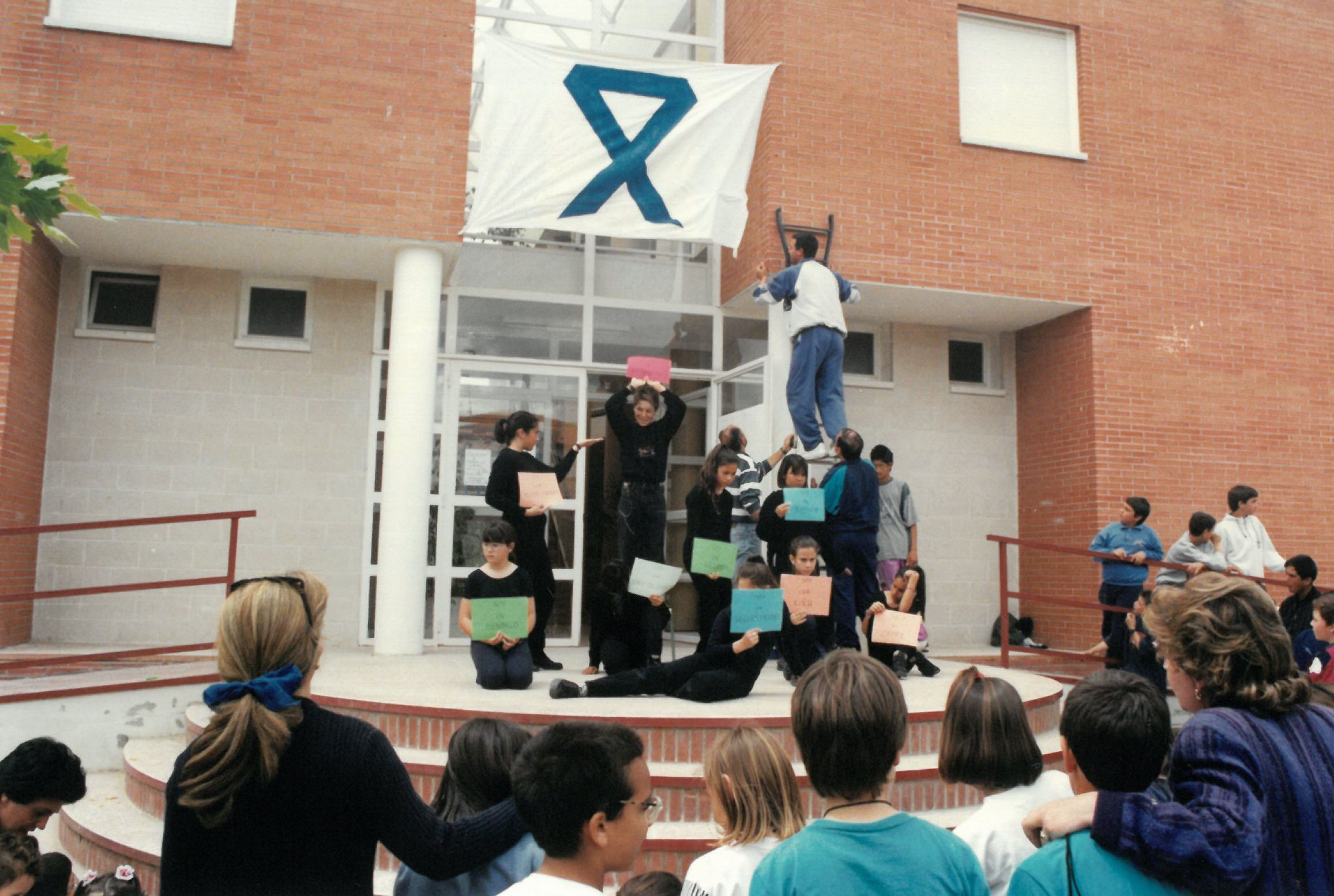 Cuelgan una pancarta con un lazo azul en el colegio. 13 de mayo de 1997.