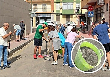 Vecinos de La Farola barren la grava de una calle tras las quejas al Ayuntamiento