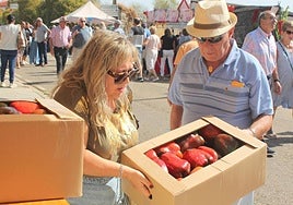 Varias personas, con cajas de pimientos compradas en la feria.