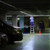 Operarios trabajan en la instalación del sistema de guiado de plazas libres y ocupadas en el primer sótano del aparcamiento.