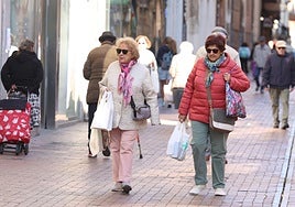 Viandantes abrigadas por la calle Teresa Gil en la mañana de este lunes.