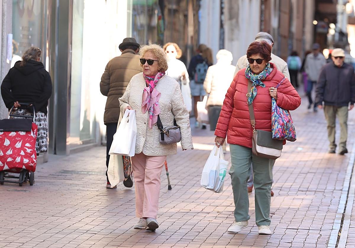 Viandantes abrigadas por la calle Teresa Gil en la mañana de este lunes.