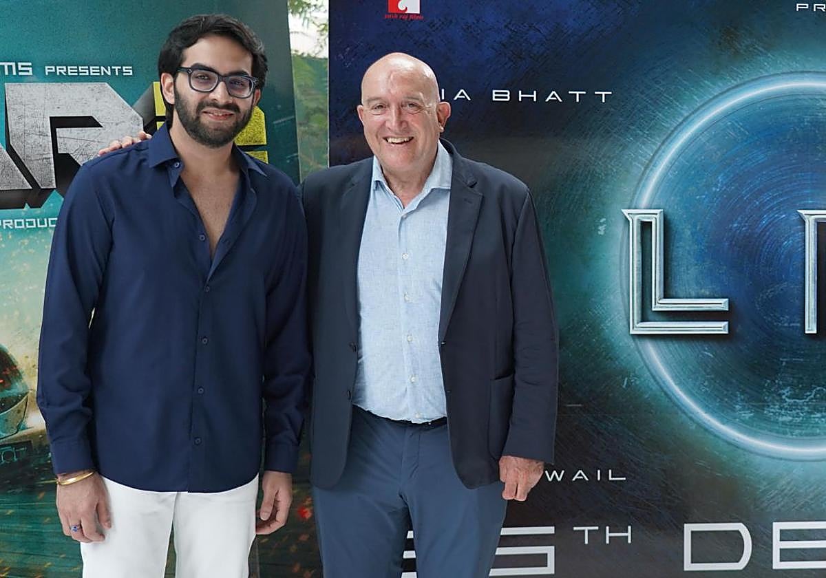 Rishabh Chopra y Jesús Julio Carnero, ante un cartel de la película Alpha.