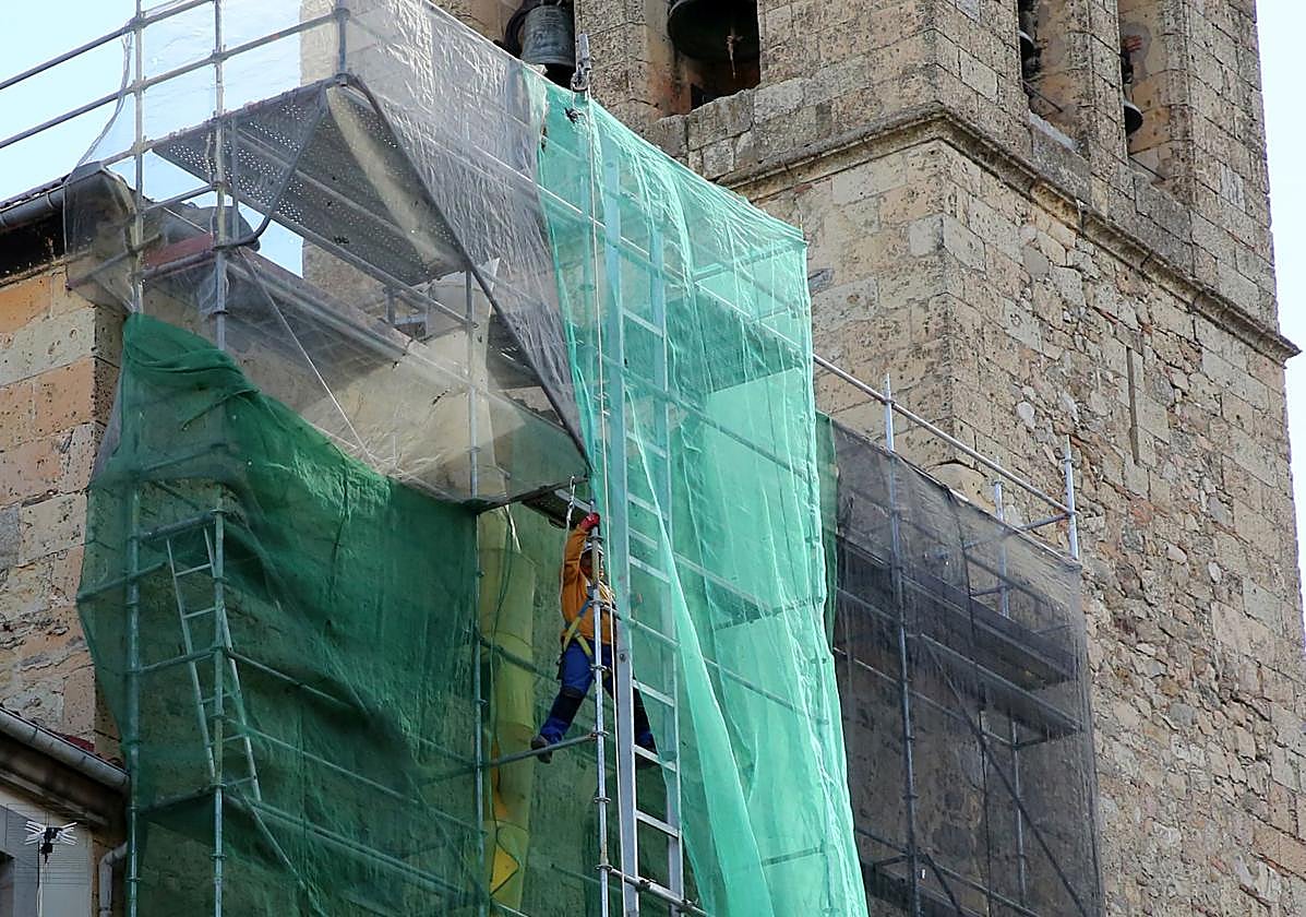 Un operario en el andamio que cubre la fachada principal de la iglesia de San Miguel.
