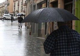 Un hombre se protege de la lluvia con su paraguas a finales de junio.