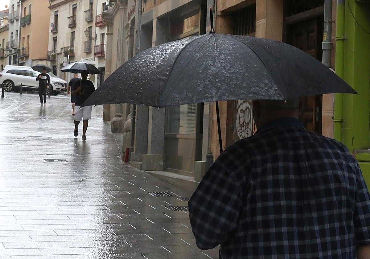 Un hombre se protege de la lluvia con su paraguas a finales de junio.