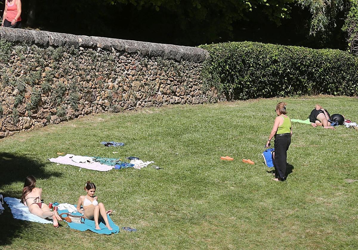 Varias personas toman el sol en la ciudad de Segovia al comienzo del verano.