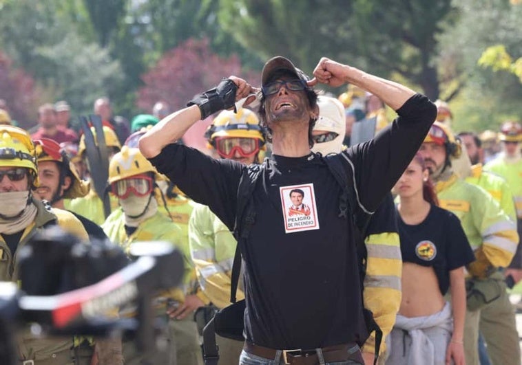Uno de los bomberos con una pegatina contra la gestión del consejero de Medio Ambiente.