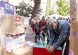 La presidenta de la federación de vecinos Antonio Machado, Margarita García, coloca sus cajas en la 'torre de las voces' levantada en la plaza de la Universidad.