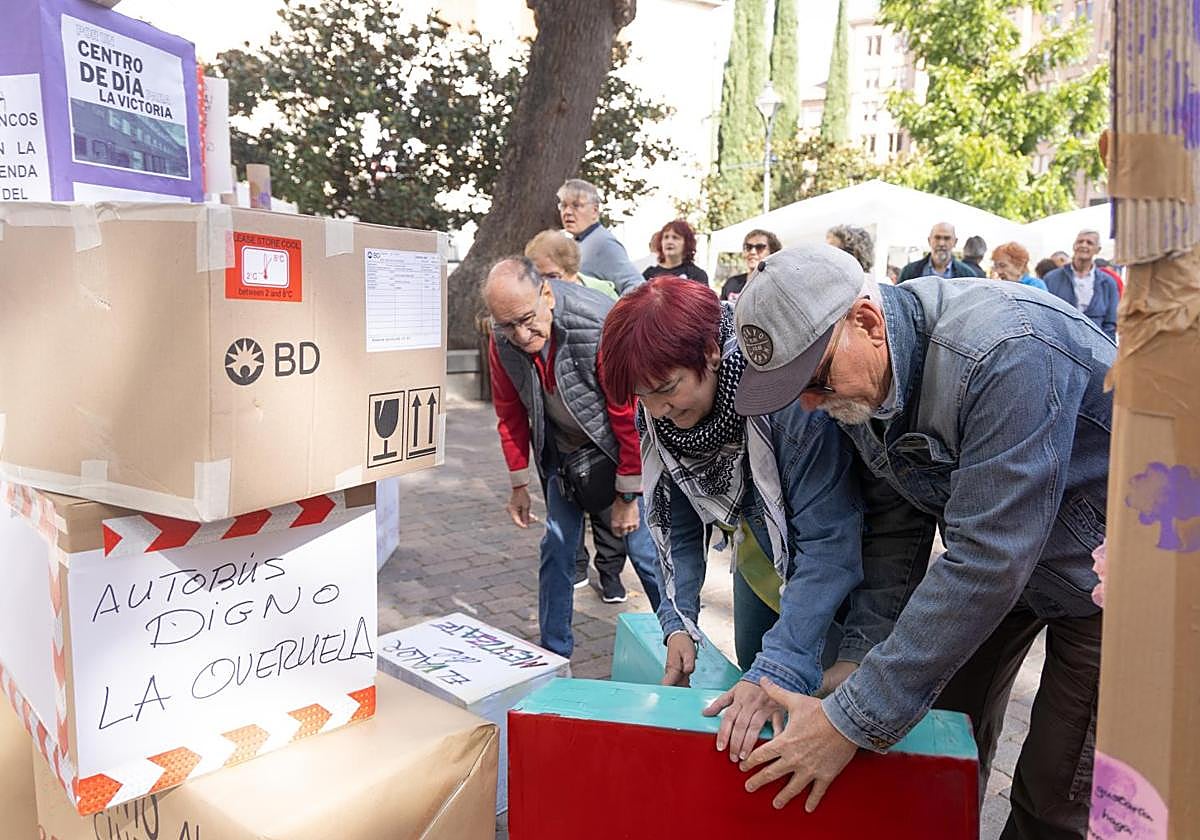 La presidenta de la federación de vecinos Antonio Machado, Margarita García, coloca sus cajas en la 'torre de las voces' levantada en la plaza de la Universidad.