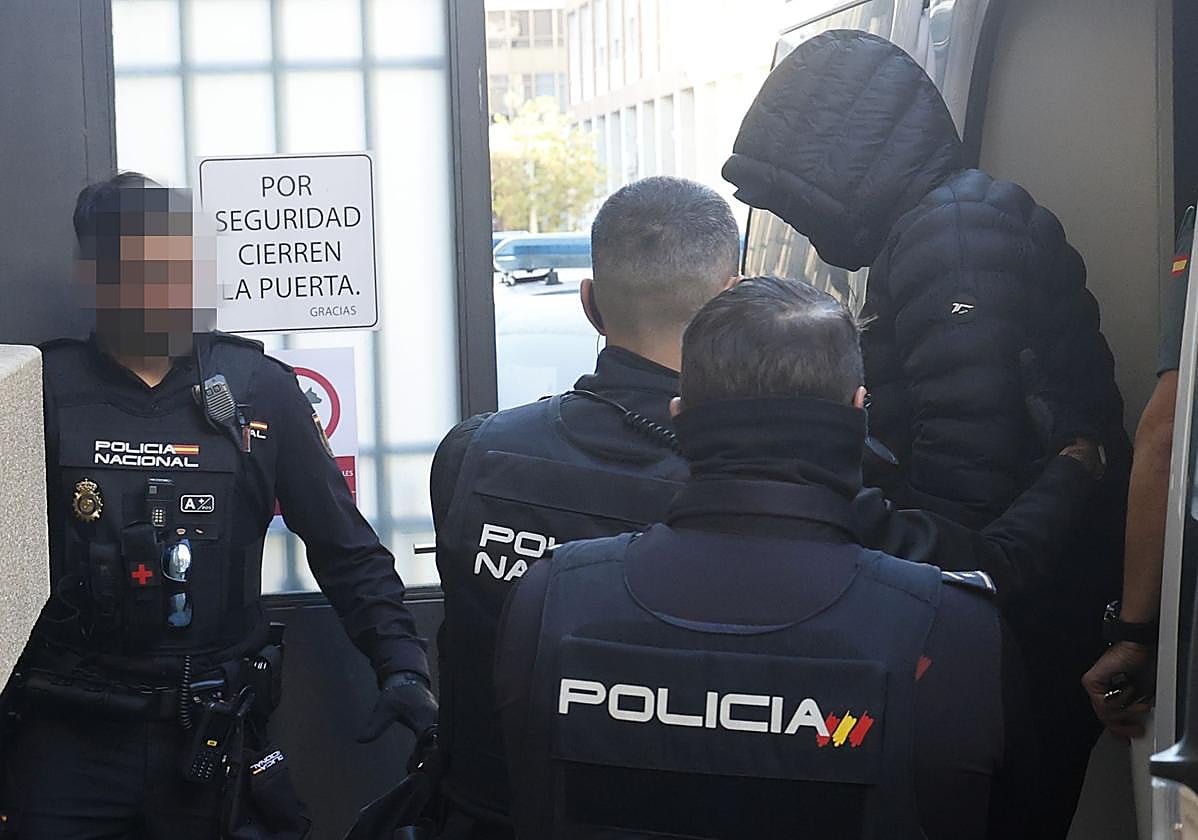 Policías nacionales escoltan a uno de los acusados a su llegada este lunes a la Audiencia de Palencia.