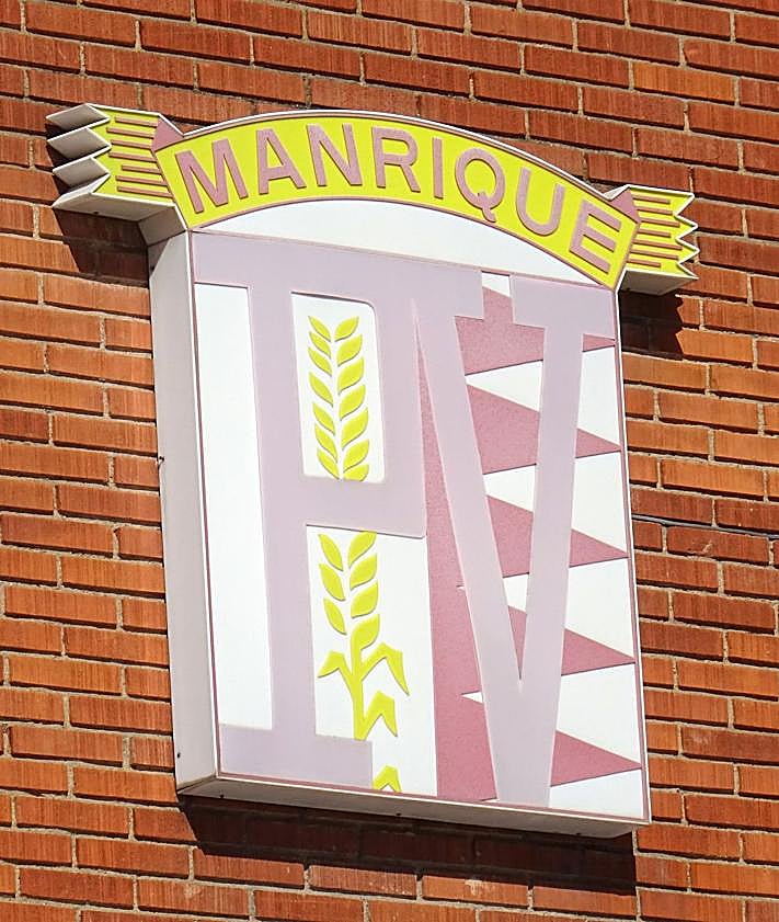 Imagen secundaria 2 - Los operarios mueven los paneles de la cubierta en las instalaciones para meterlas por el lateral de la nave. Debajo, a la izquierda, detalle del logo de la panificadora.