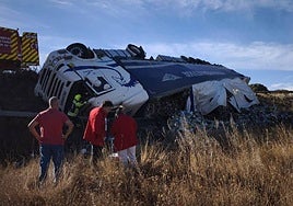 Los equipos de emergencia trabajan junto al camión tras el accidente en Villaconancio.
