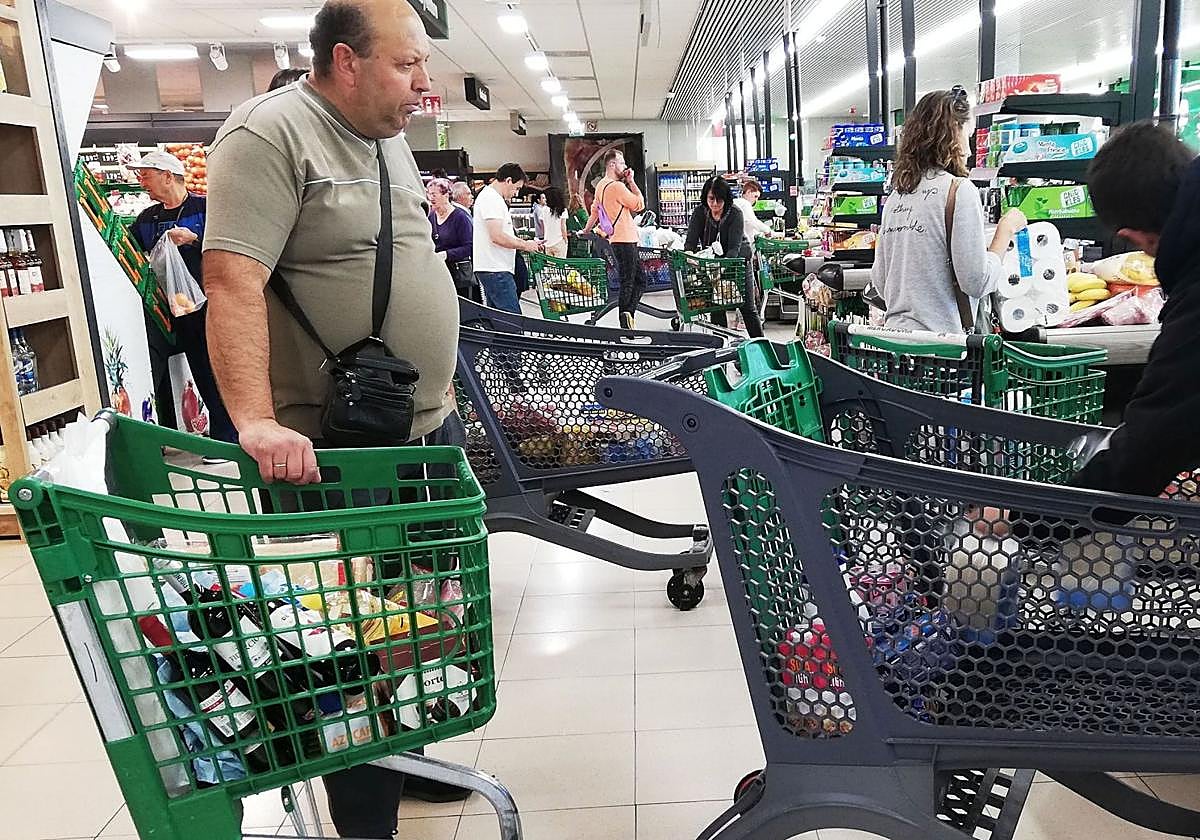 Clientes pasan por caja con sus carritos de la compra en un supermercado de Segovia.