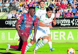 El jugador de la Gimnástica Ayán (izq.) trata de llevarse el balón ante un rival del Coruxo este pasado domingo.