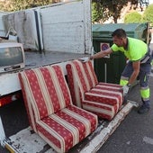 Un operario de Palencia Deslumbra recoge dos sillones abandonados.