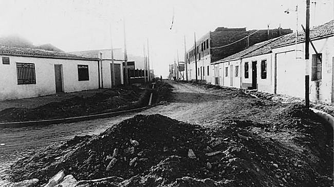 Imagen antes - A la izquierda, obras para asfaltar las calles de Las Flores en los años 80. A la dereceha, estado actual de las calles del barrio.