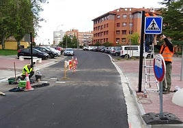 Los operarios instalan la nueva señalización y colocan las tiras led en la calzada de la calle Manuel Silvela ante el colegio Tierno Galván.
