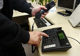 Una persona marca un número en un teléfono fijo en una imagen de archivo.