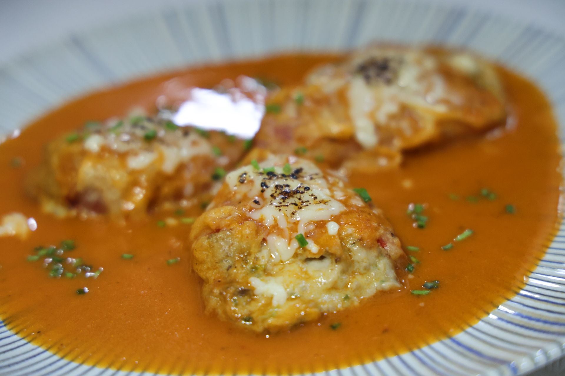 Primer plato, pimientos rellenos con boletus y setas, gratinado de queso y salsa de tomate.