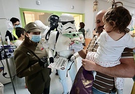 Una niña recibe un regalo y un diploma del Imperio Galáctico, de mano de los personajes de Star Wars