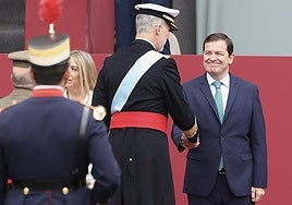 Fernández Mañueco saluda al Rey Felipe durante el acto de homenaje a la bandera nacional y al desfile militar con ocasión del día de la Fiesta Nacional.