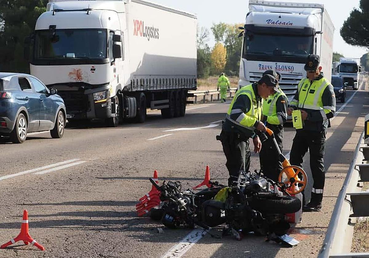 Agentes de la Guardia Civil inspeccionan la motocicleta accidentada. Al fondo, el camión implicado en el siniestro.